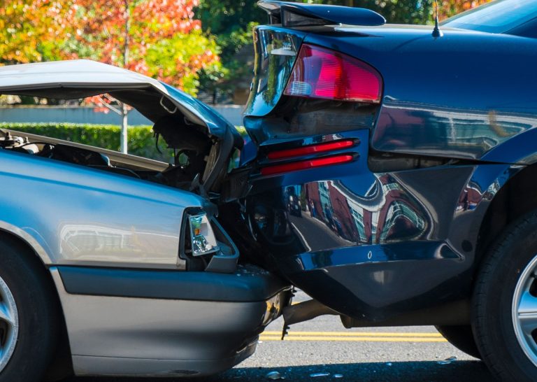 A car accident, where one car has driven into the back of another causing damage to both cars.