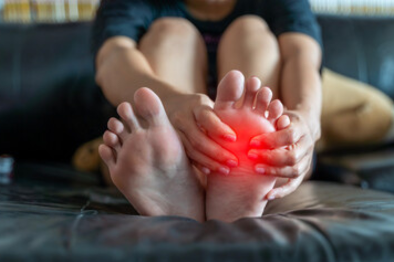 A person holding their foot in pain